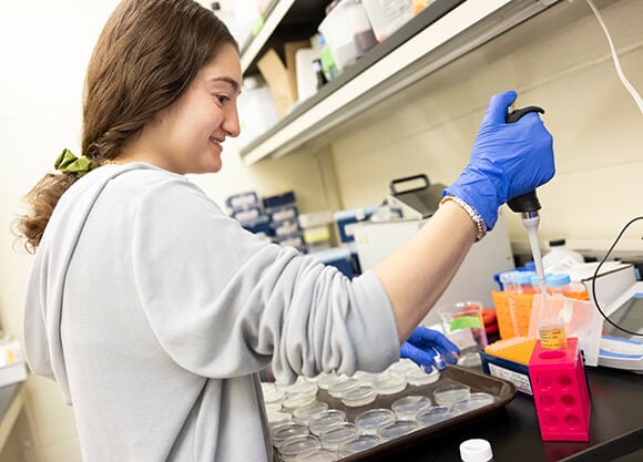 Student pipetting materials in a science laboratory