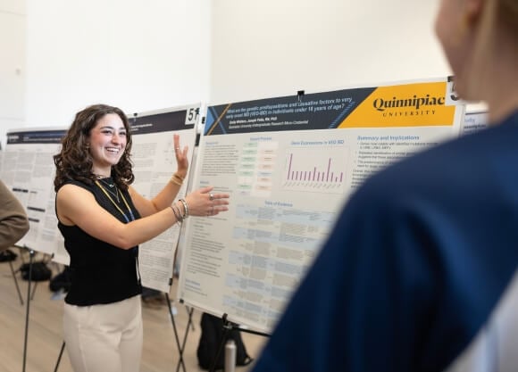 Emily Whitters presenting her poster at Illuminate: The Quinnipiac Student Expo.